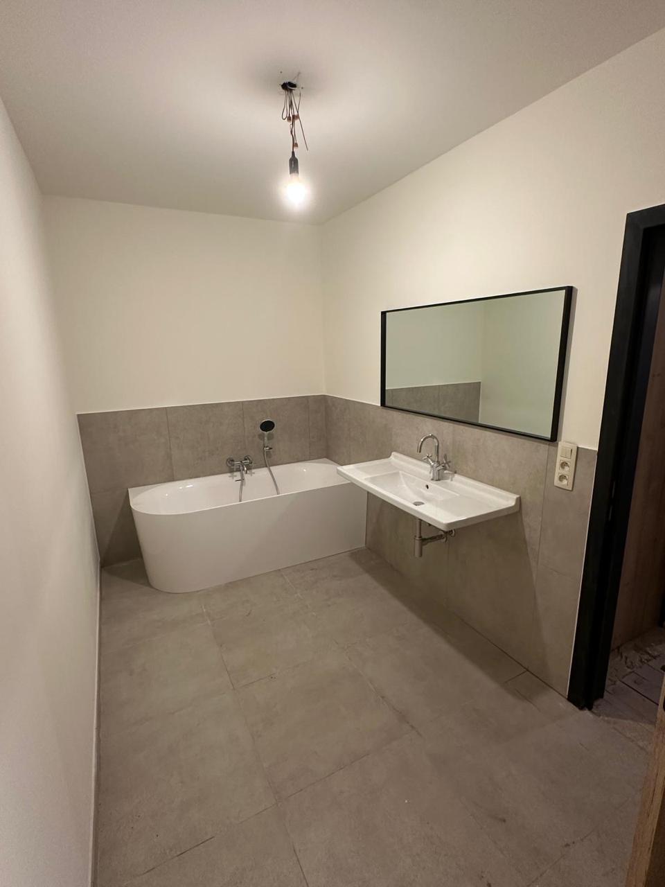 Badkamer in betonlook met vrijstaand hoekbad - Na