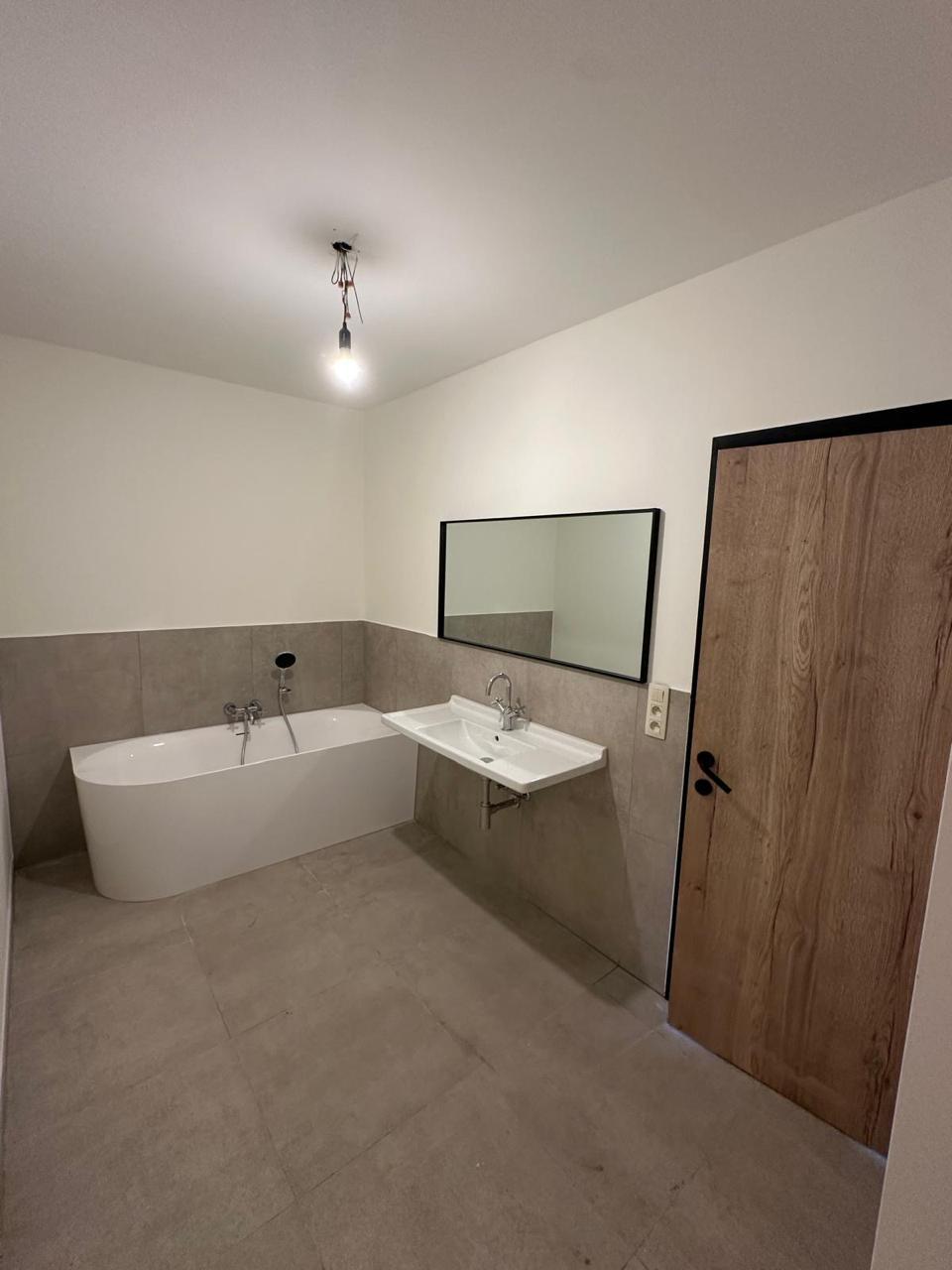 Badkamer in betonlook met vrijstaand hoekbad - Bad