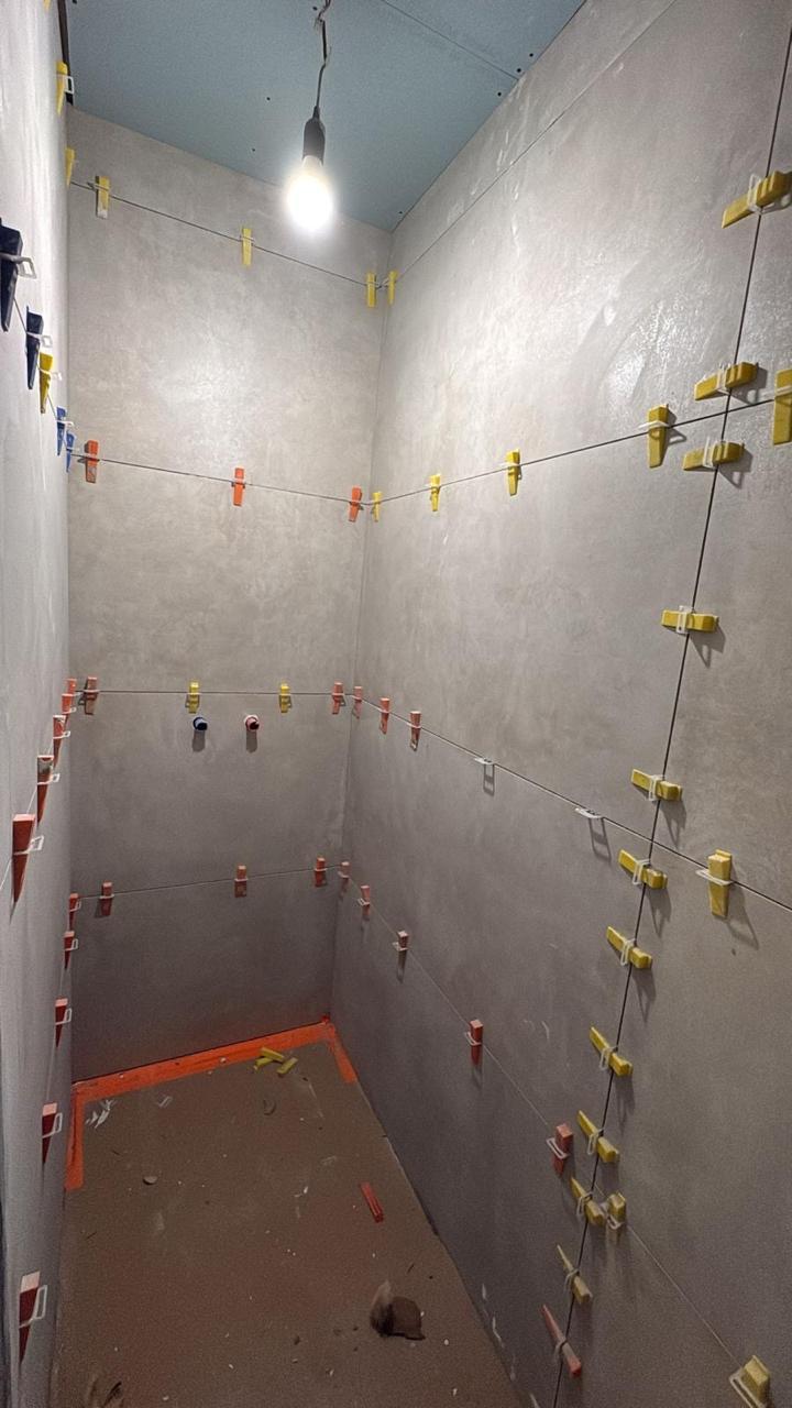 Badkamer in betonlook met vrijstaand hoekbad - Tegelwerk