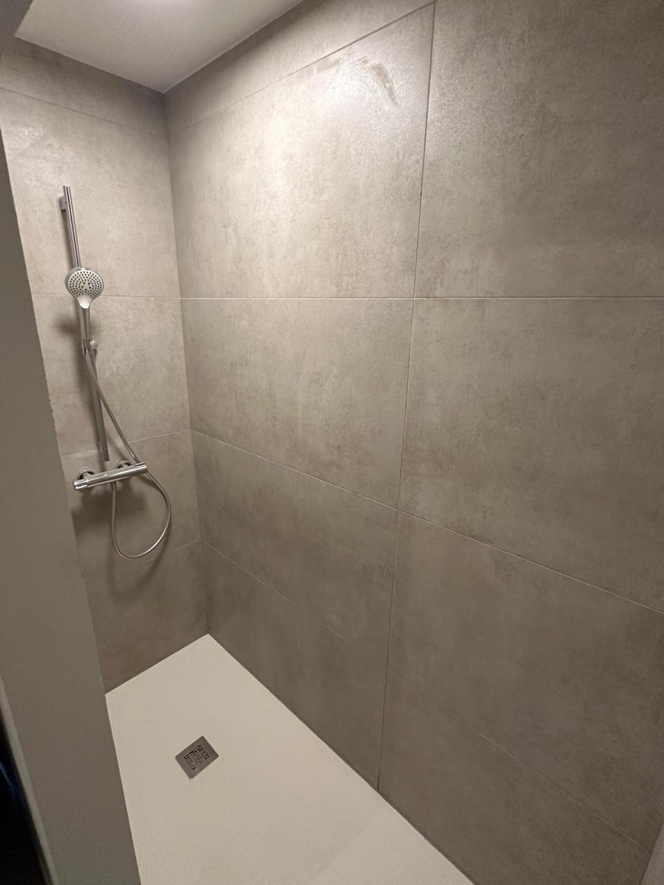 Badkamer in betonlook met vrijstaand hoekbad - Inloopdouche